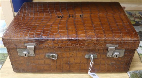 A crocodile suitcase, with silver fittings